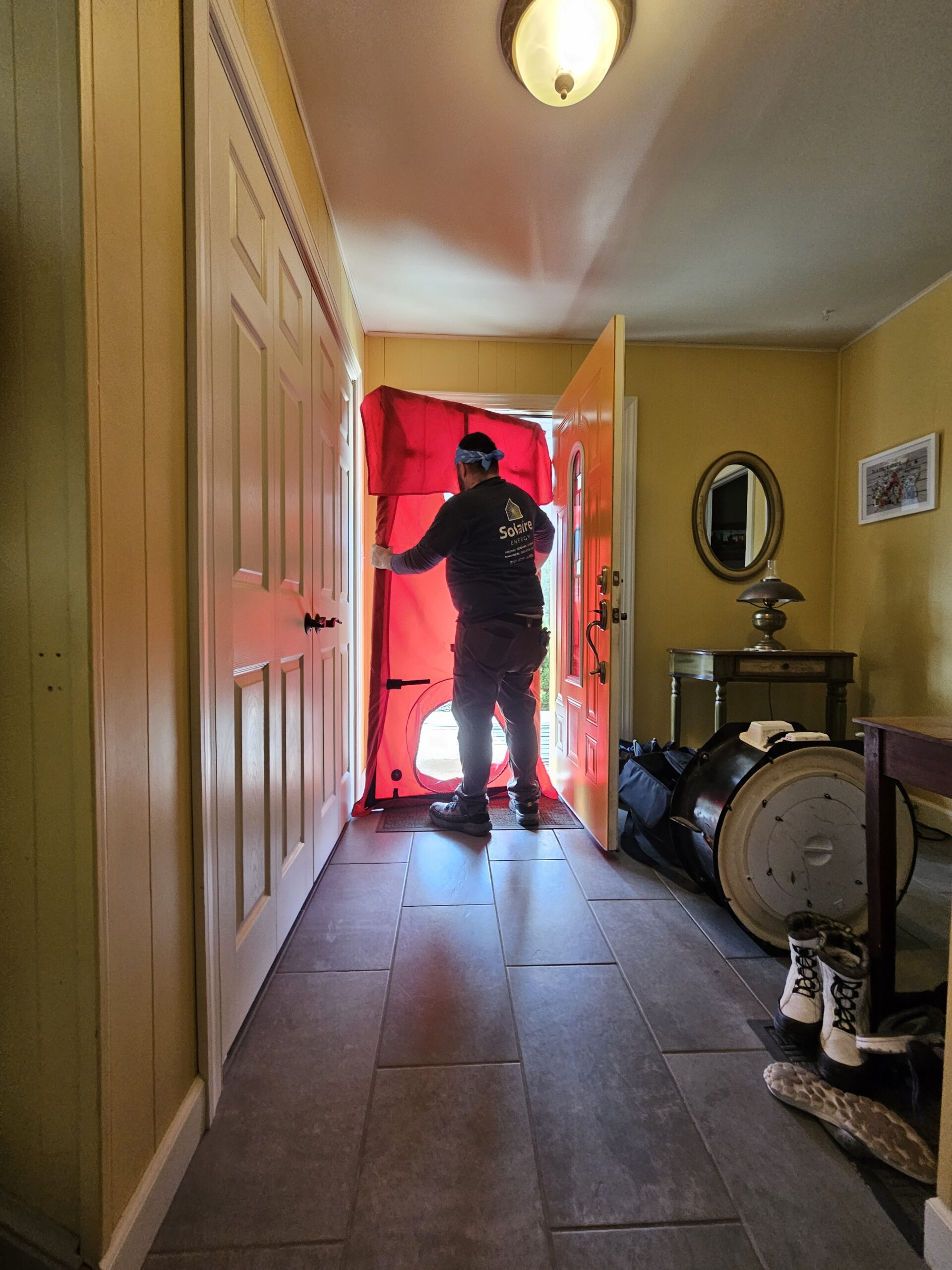Solaire Energy conducting blower door testing for weatherization on a PA home